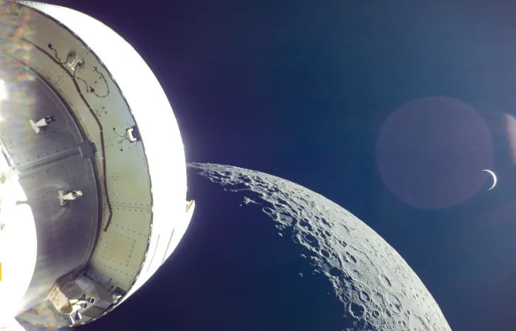 Orion og den europeiske servicemodulen under den første ferden, med månen og jorda i bakgrunnen.