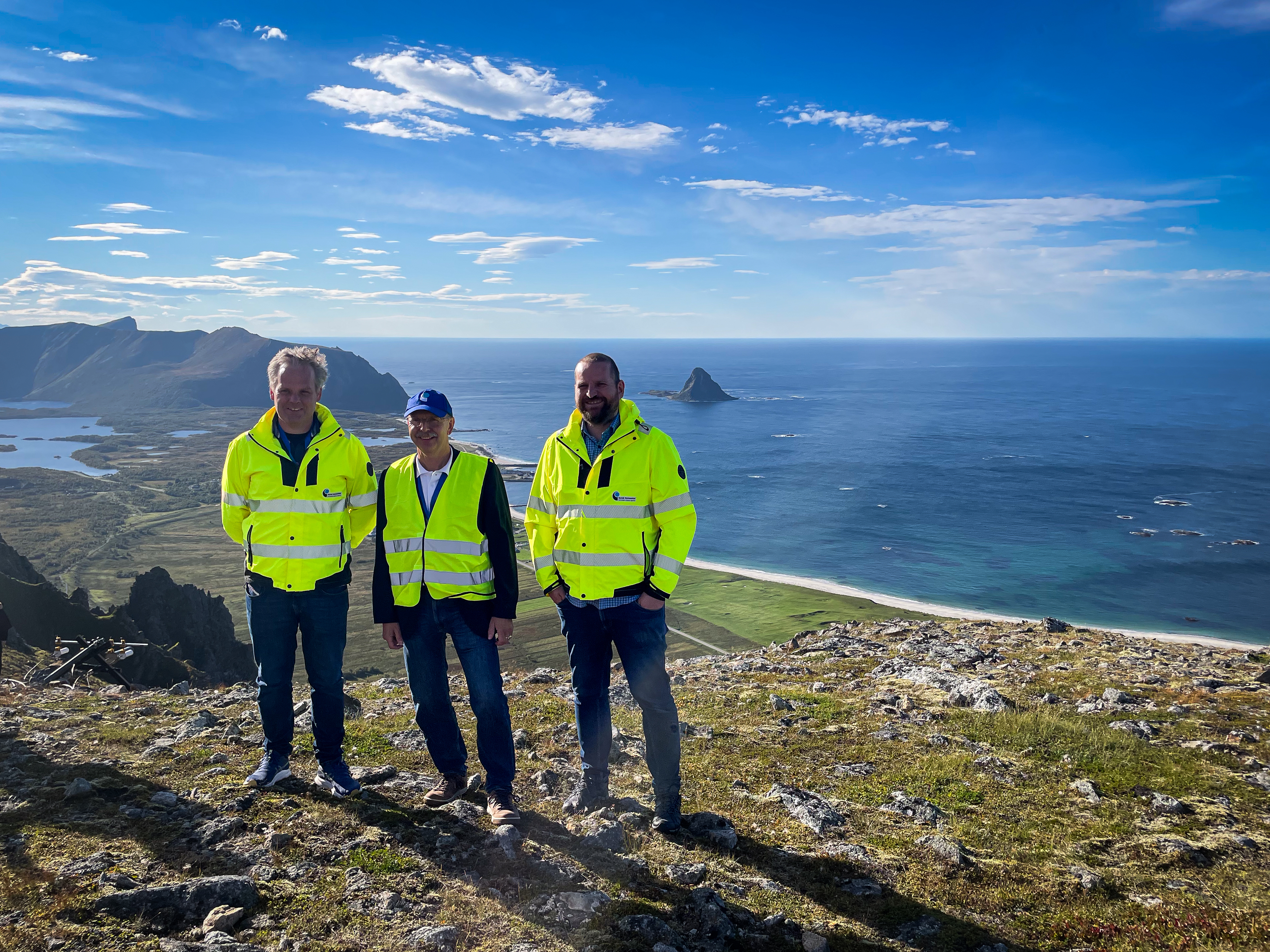 Fra venstre Øystein Glomsvoll, Steinar Thomsen og Kristian Svartveit fra Norsk Romsenter på Jammetest 2024. Testområdet ved Bleik i bakgrunnen.
