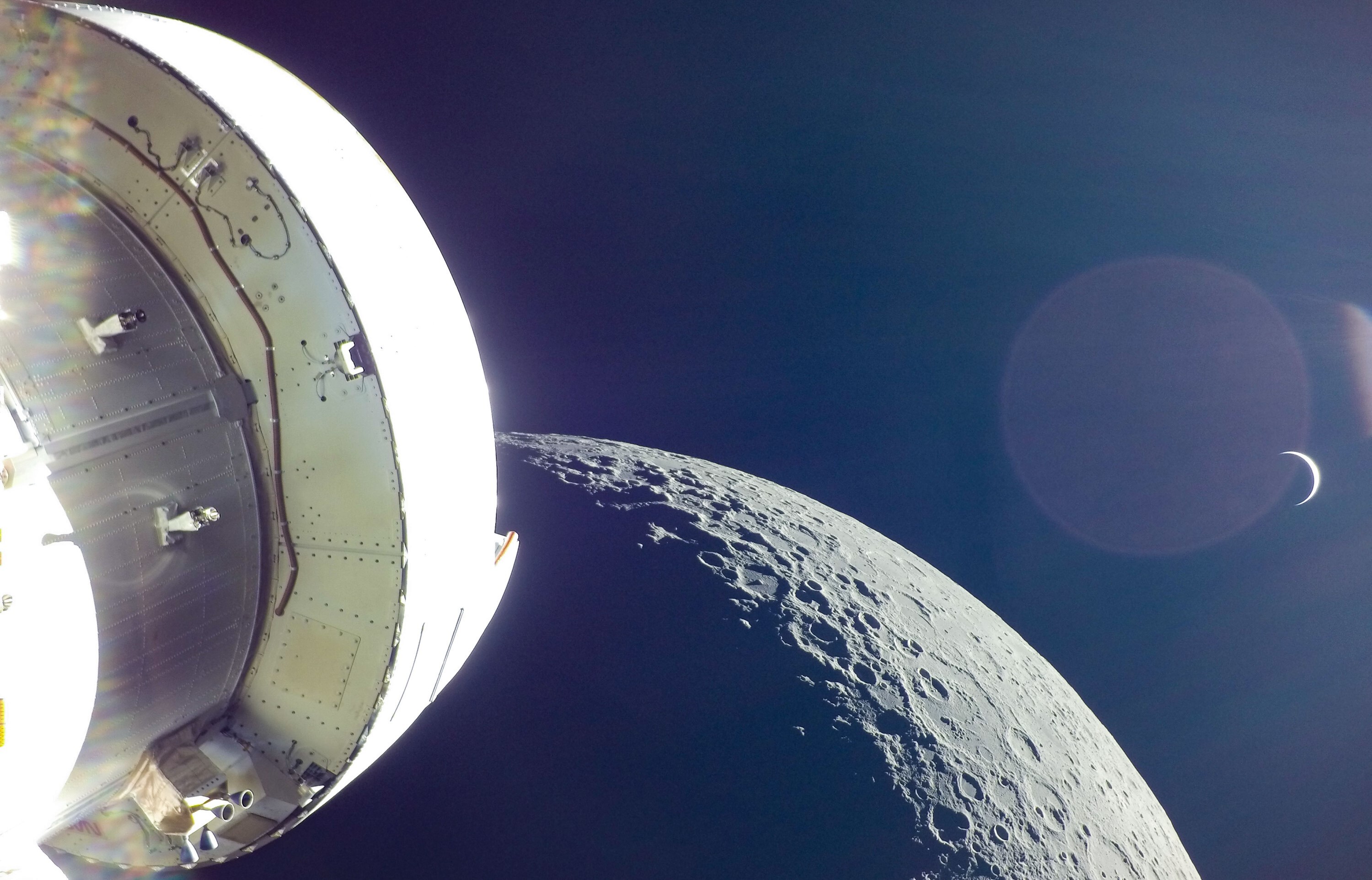 Orion og den europeiske servicemodulen under den første ferden, med månen og jorda i bakgrunnen.